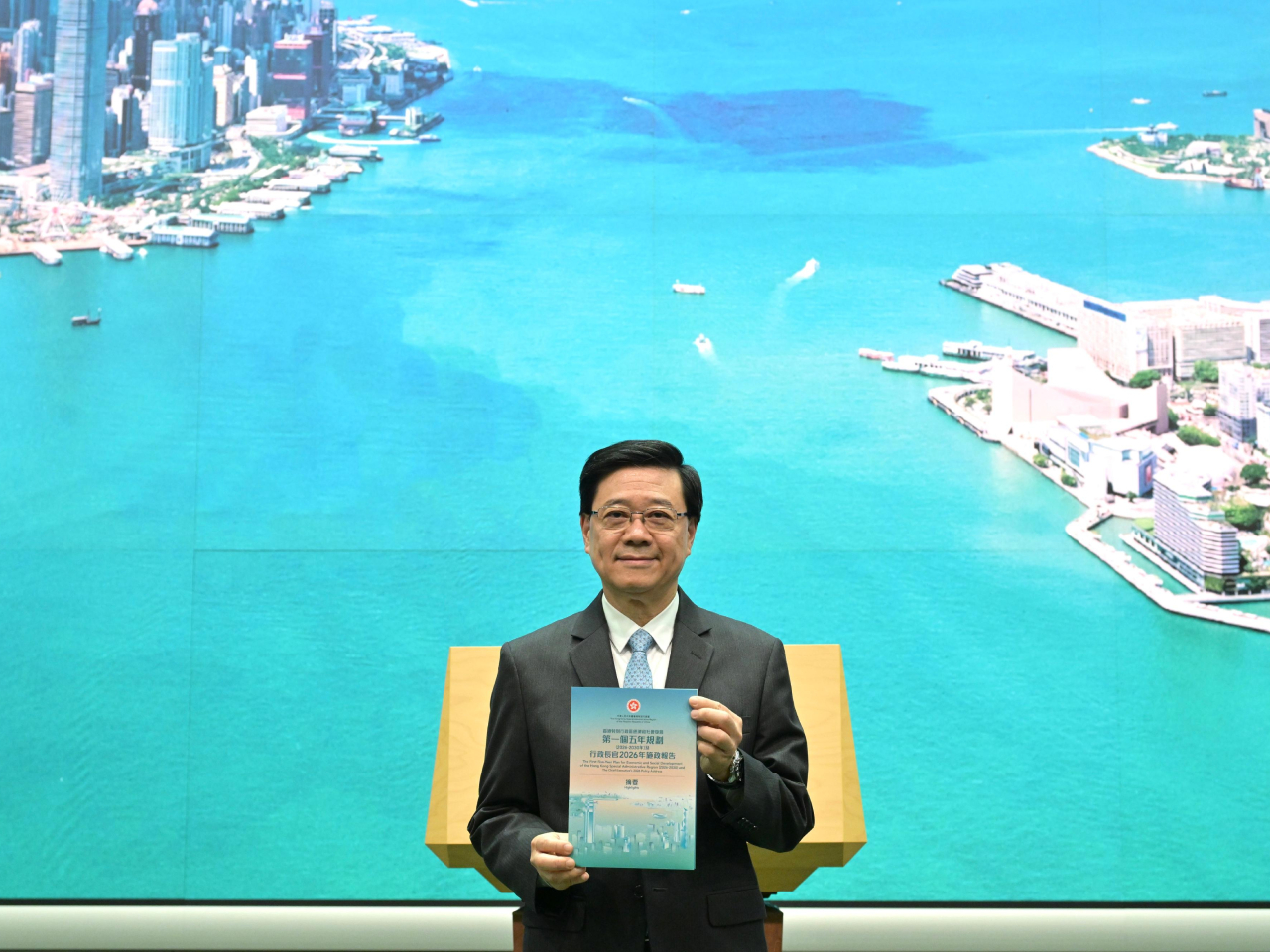 政府製作一套兩冊《摘要》有兩份文件重點介紹，封面以維港在晨光下欣欣向榮的景象。(政府新聞處)