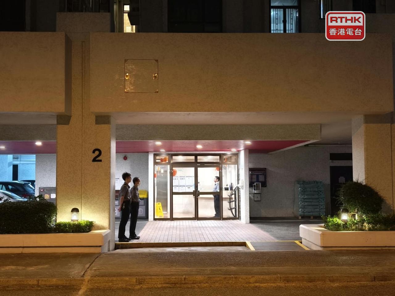 事發在杏花邨2座一個單位，保安人員在大門外把守。（葉美薏攝）