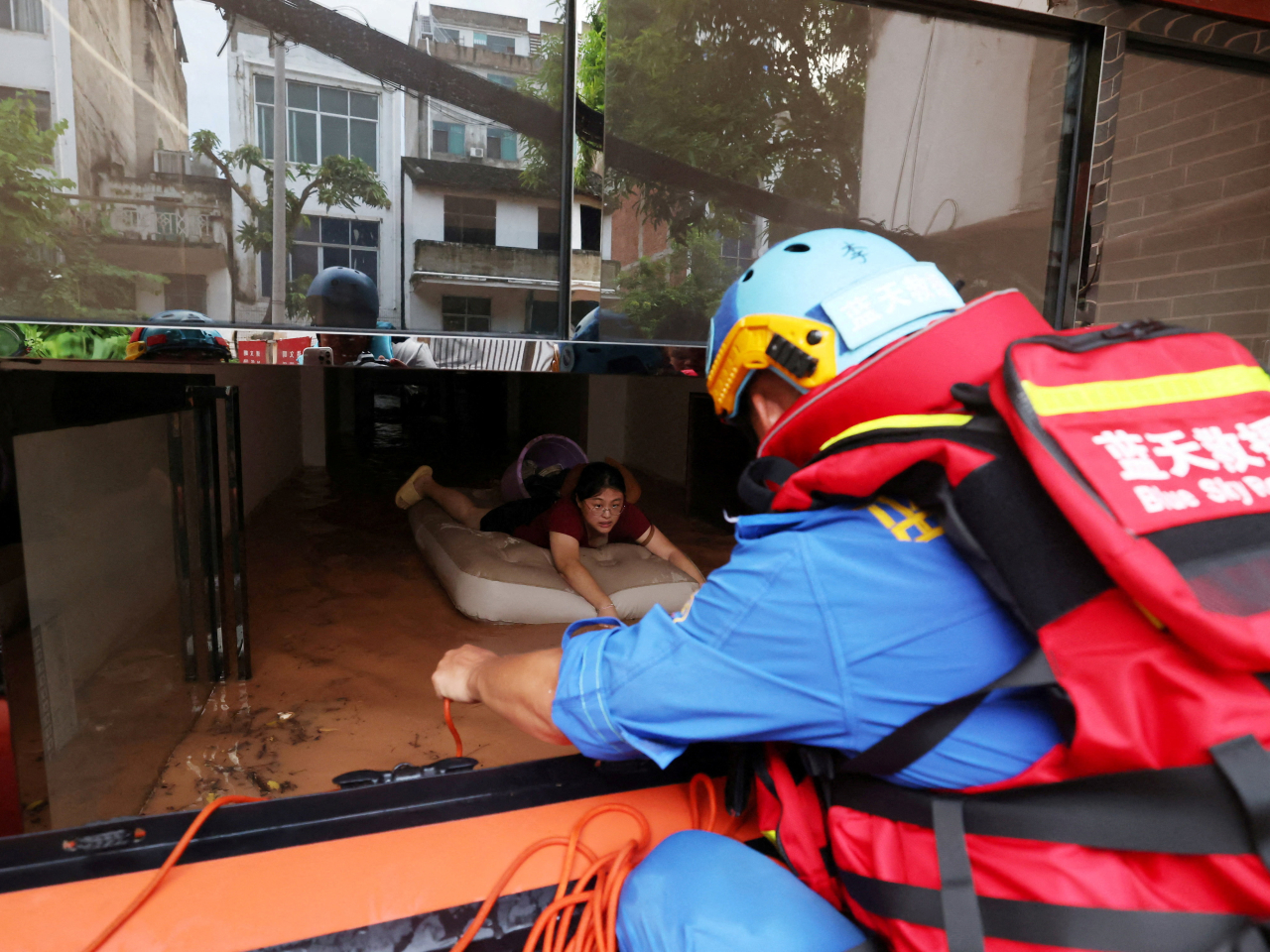 Rescue workers evacuate a resident stranded by flooding in Ningming county, Chongzuo, in Guangxi. Photo: cnsphoto via Reuters