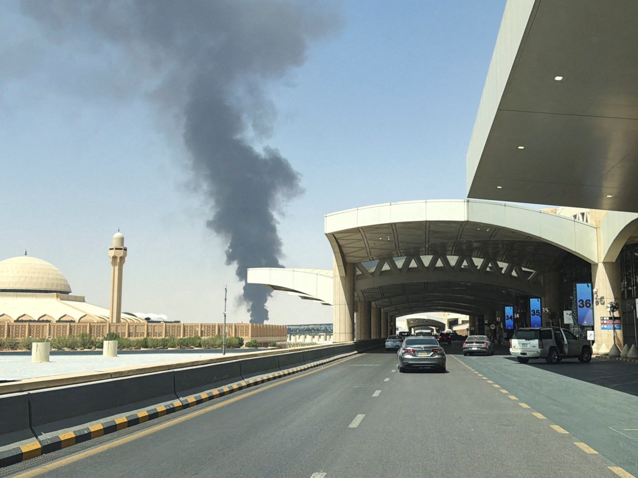 A picture taken with a mobile phone shows a large plume of black smoke rising from the fuel storage depot at King Khalid International Airport, in Riyadh, Saudi Arabia. Photo: Reuters