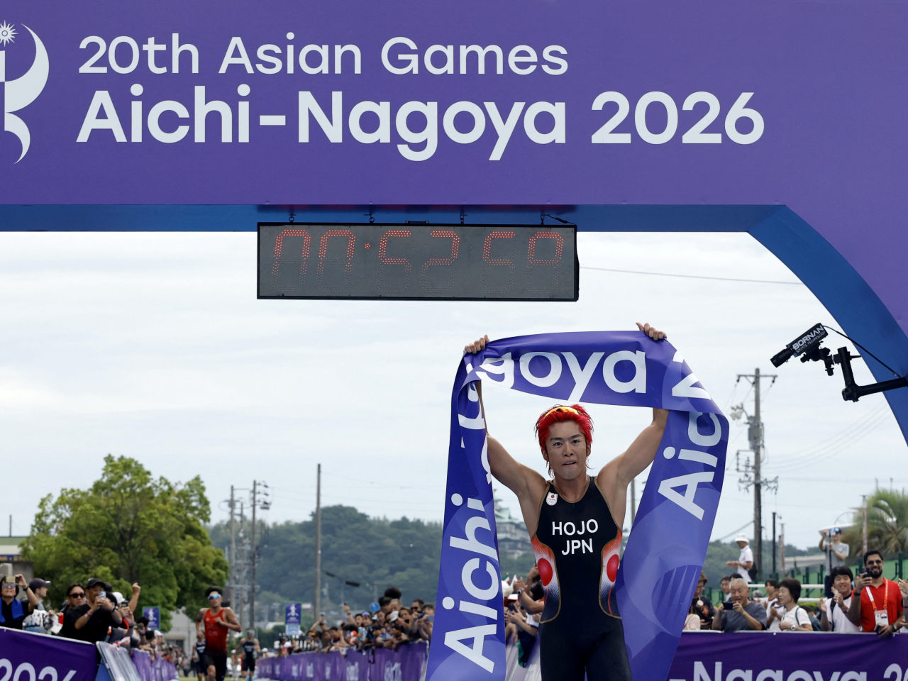 Japan's Takumi Hojo celebrates as he crosses the line to win the gold medal in the men's individual final. Photo: Reuters