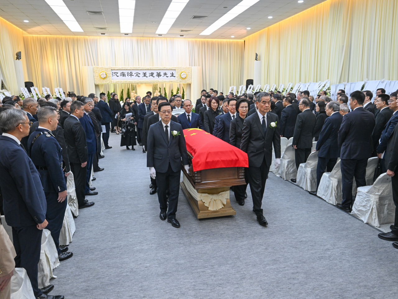 董建華的靈柩由治喪委員會副主任委員梁振英、行政長官李家超，以及國務院港澳辦副主任徐啟方等人扶靈。（鍾家銘攝）
