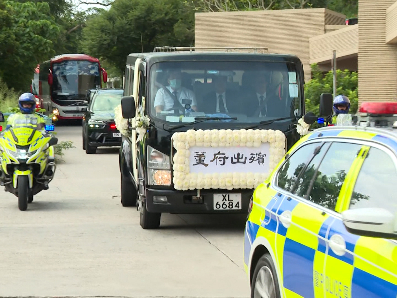 董建華的靈柩蓋上國旗，在警車開路下移送哥連臣角火葬場。（陳永祥攝）