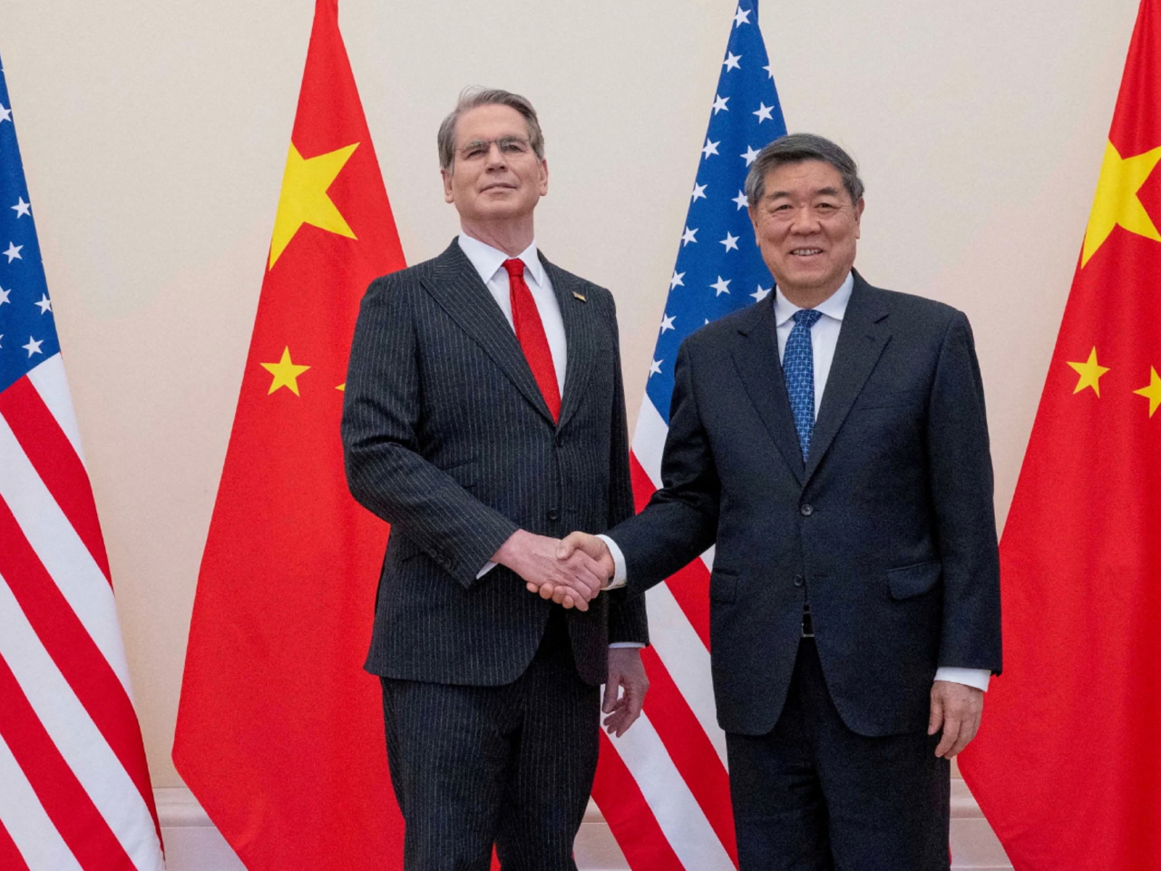 中美經貿磋商舉行之前，中共中央政治局委員、國務院副總理何立峰，與美國財政部長貝森特握手。（路透社）