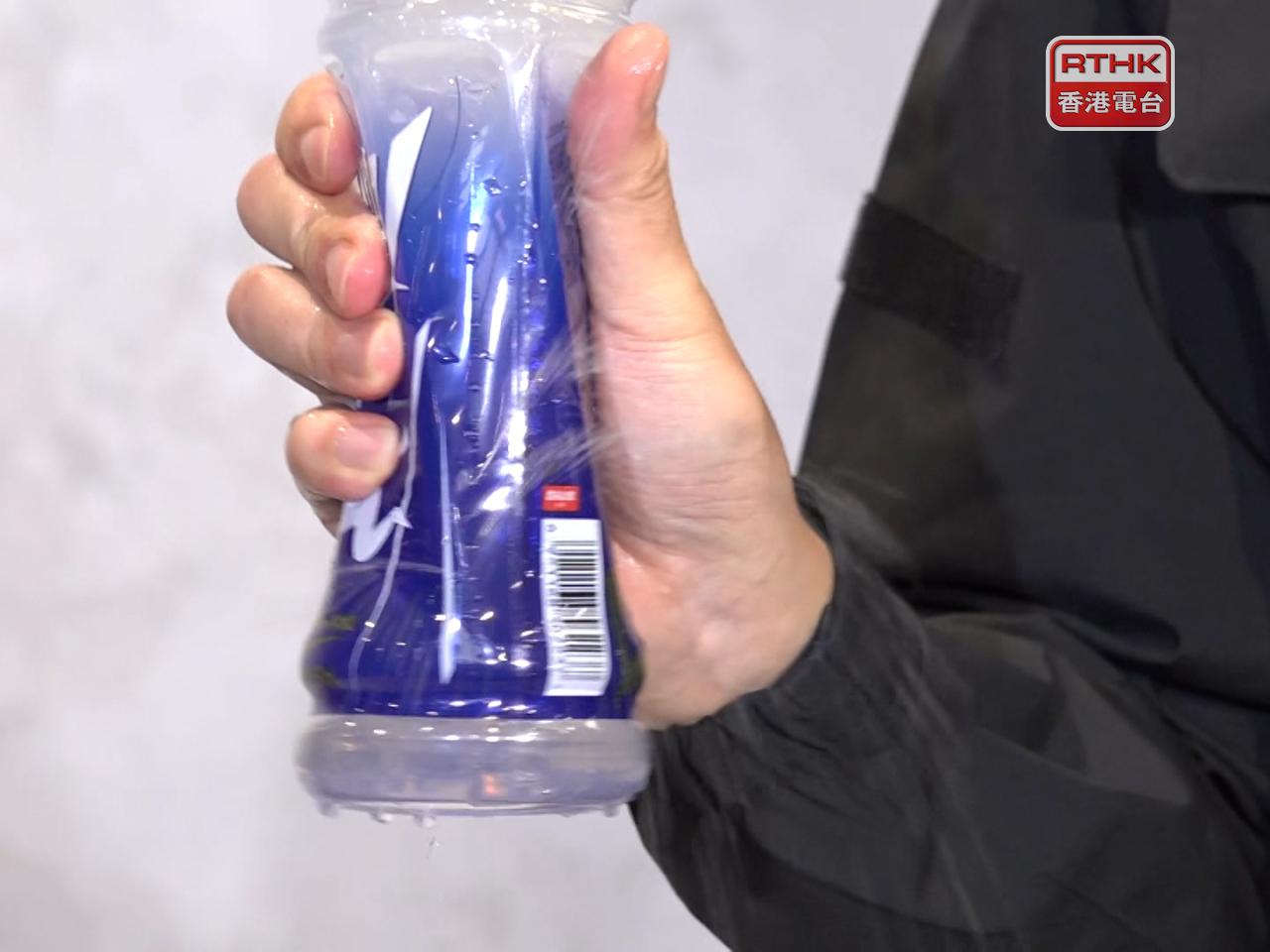 Police demonstrate how the tear-off label design created the false impression that the bottled drink was leaking. Photo: RTHK