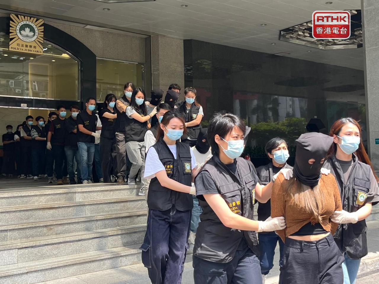 澳門司警中午將十多名涉嫌操控賣淫及犯罪集團的男女，押往檢察院偵訊。（鄭月明攝）