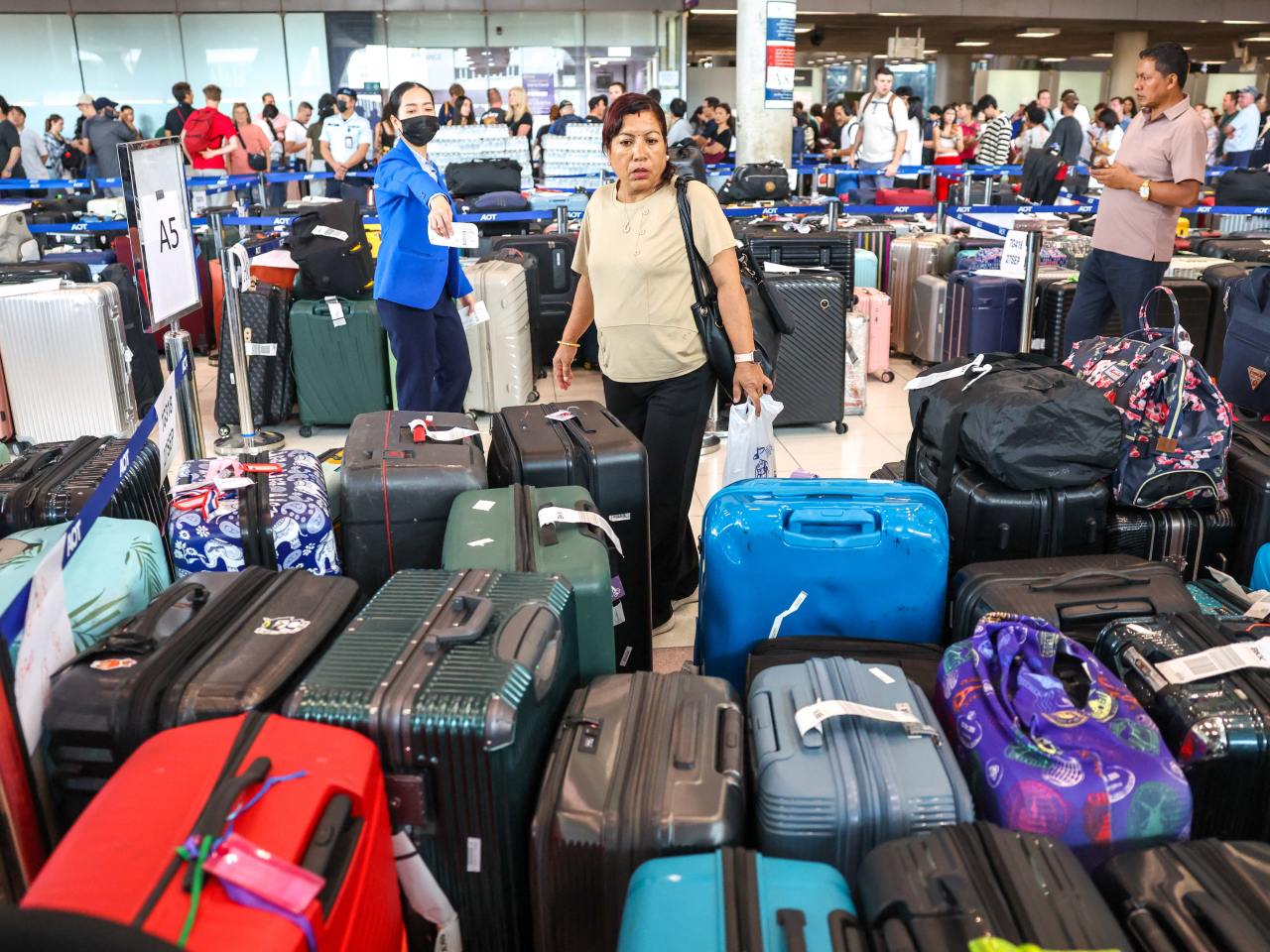 A long line forms for travellers looking to reclaim luggage as flooding disrupts Thai Airway's ground operations at Suvarnabhumi International Airport. Photo: Reuters