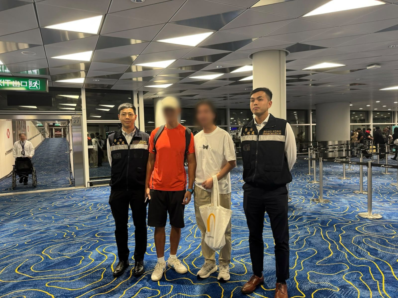 該名港人（左二）在入境處協助在外香港居民小組成員陪同下，返港與家人團聚。（政府新聞處）