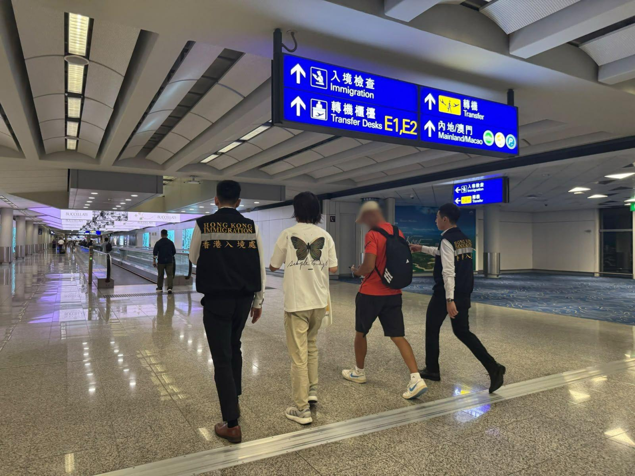 該名港人（右二）在入境處協助在外香港居民小組成員陪同下返港。（政府新聞處）