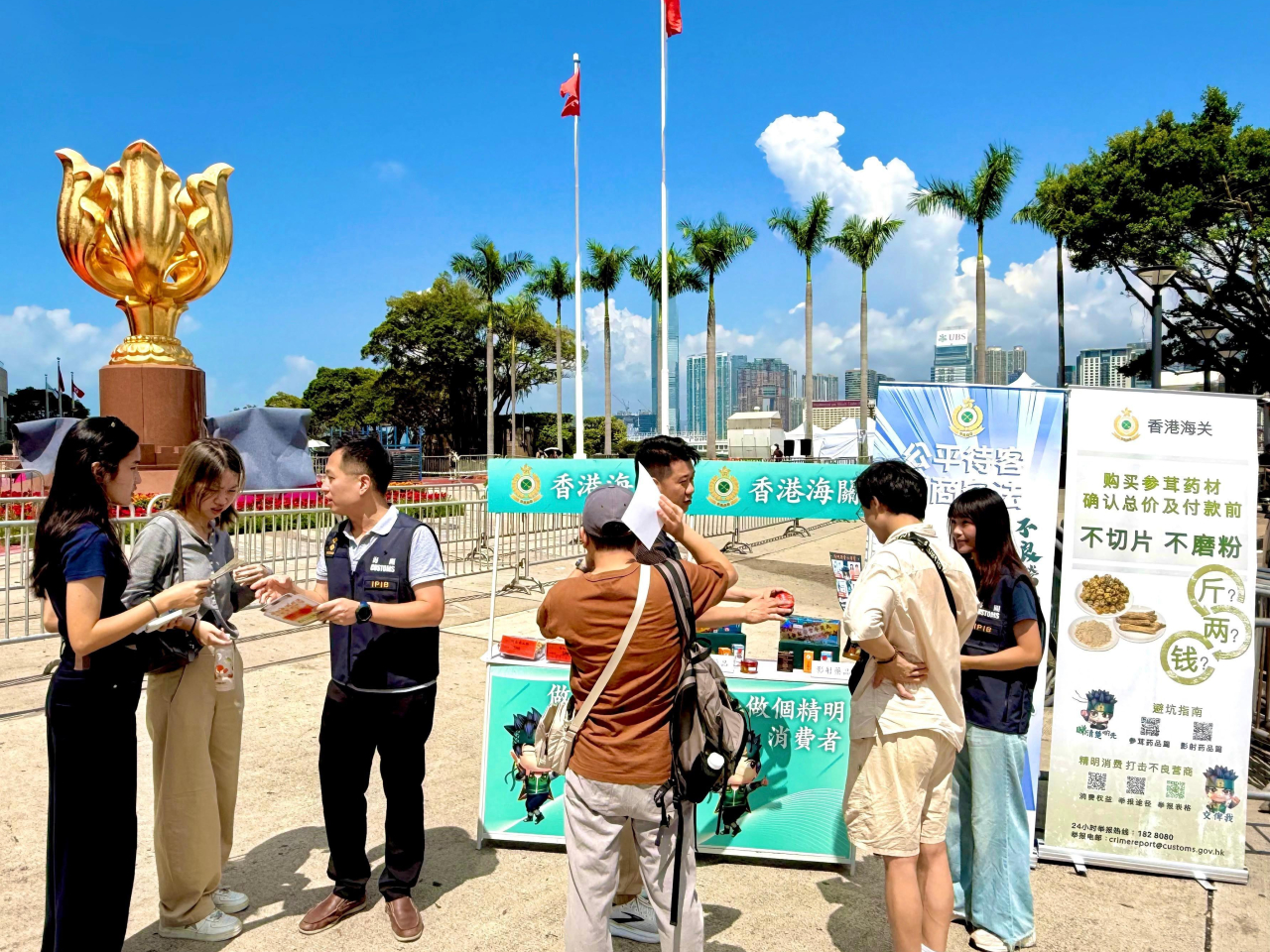 港海關人員在金紫荊廣場向旅客派發宣傳單張。(政府新聞處)
