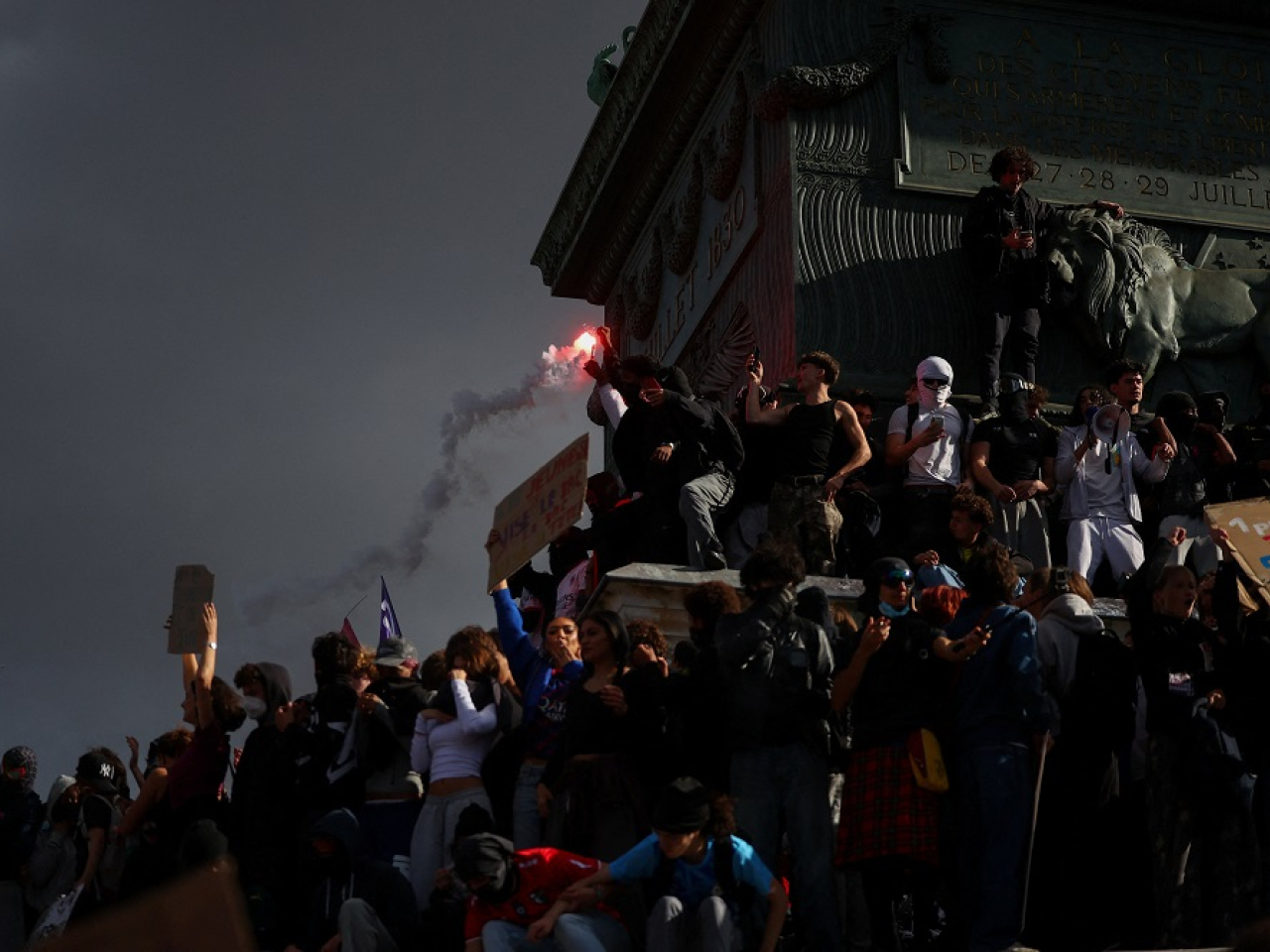 Young demonstrators gather on the July Column in Paris's Place de la Bastille, some brandishing fireworks. Photo: Reuters