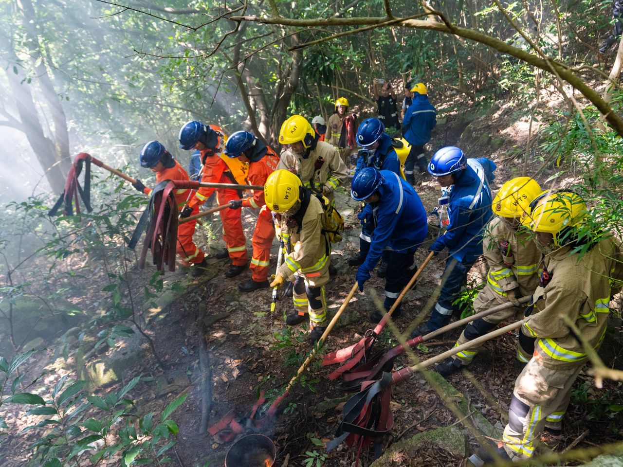 消防處、民眾安全服務隊和漁農自然護理署人員以山草拍模擬撲滅山火。（政府新聞處）