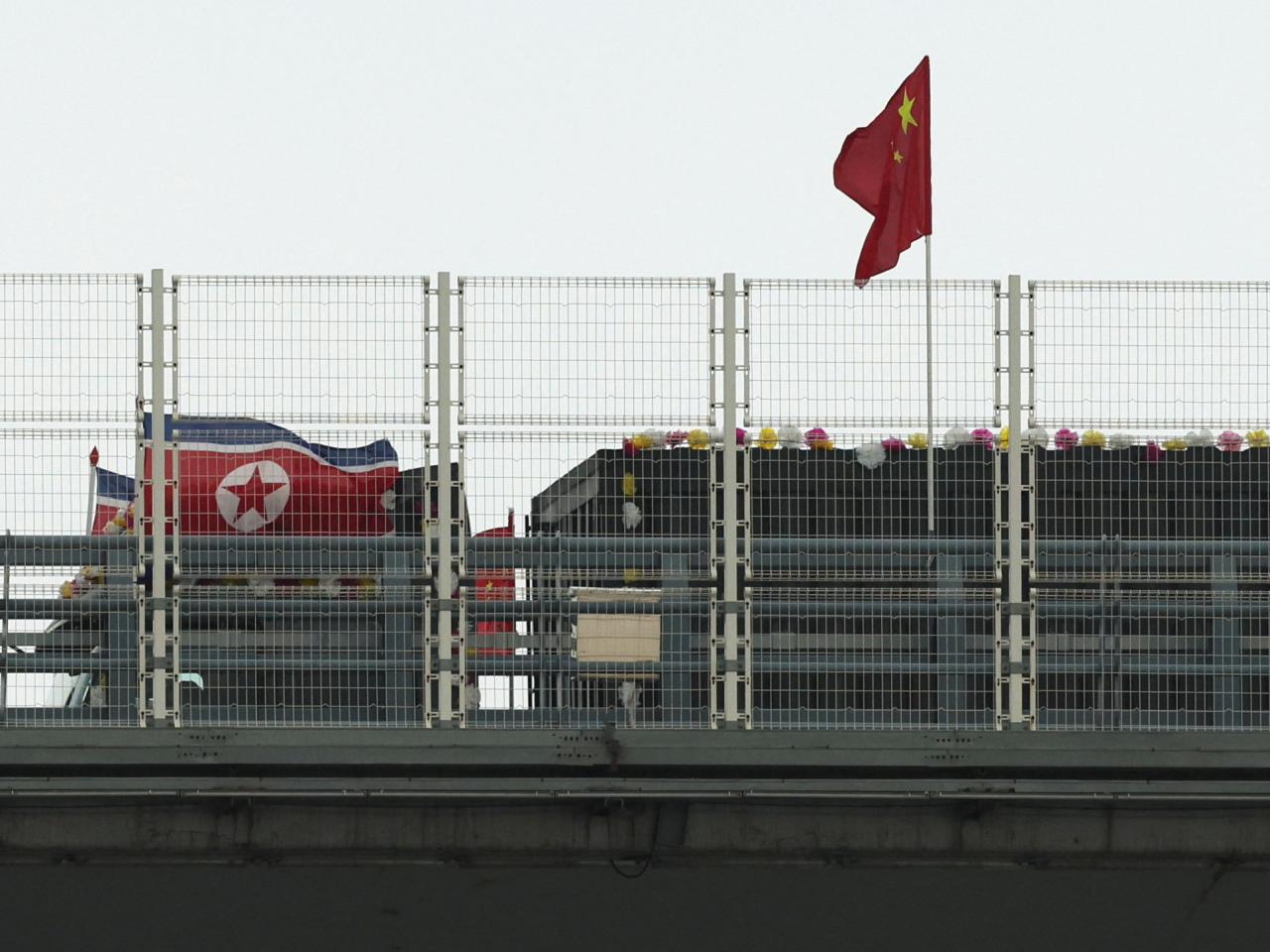 A truck sporting DPRK flags and adorned with flowers heads for Dandong from the Sinuiju end of the bridge. Photo: Reuters