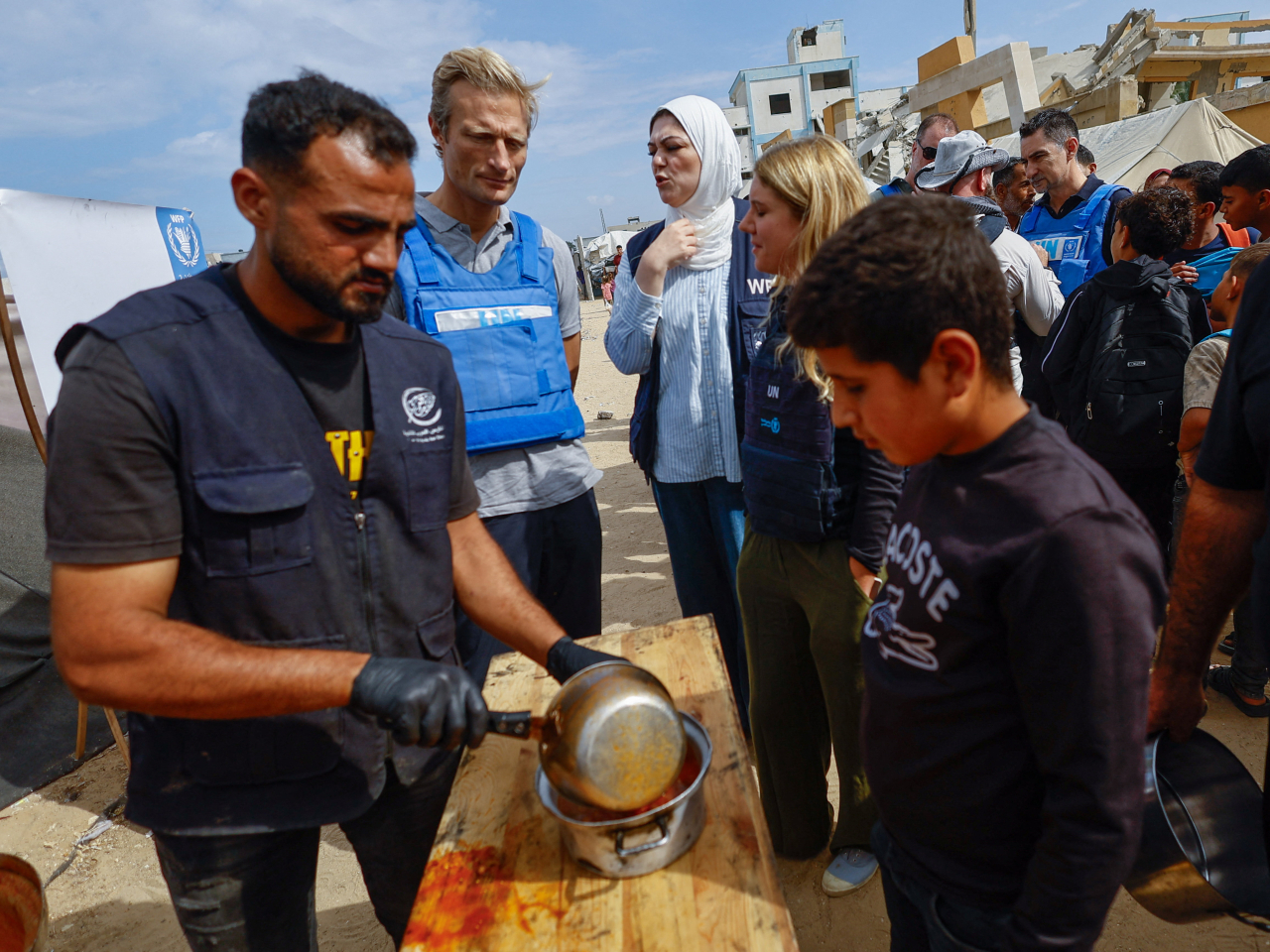 A World Food Programme officer watches as soup is dispensed out in Deir Al-Balah in central Gaza Strip. Photo: Reuters