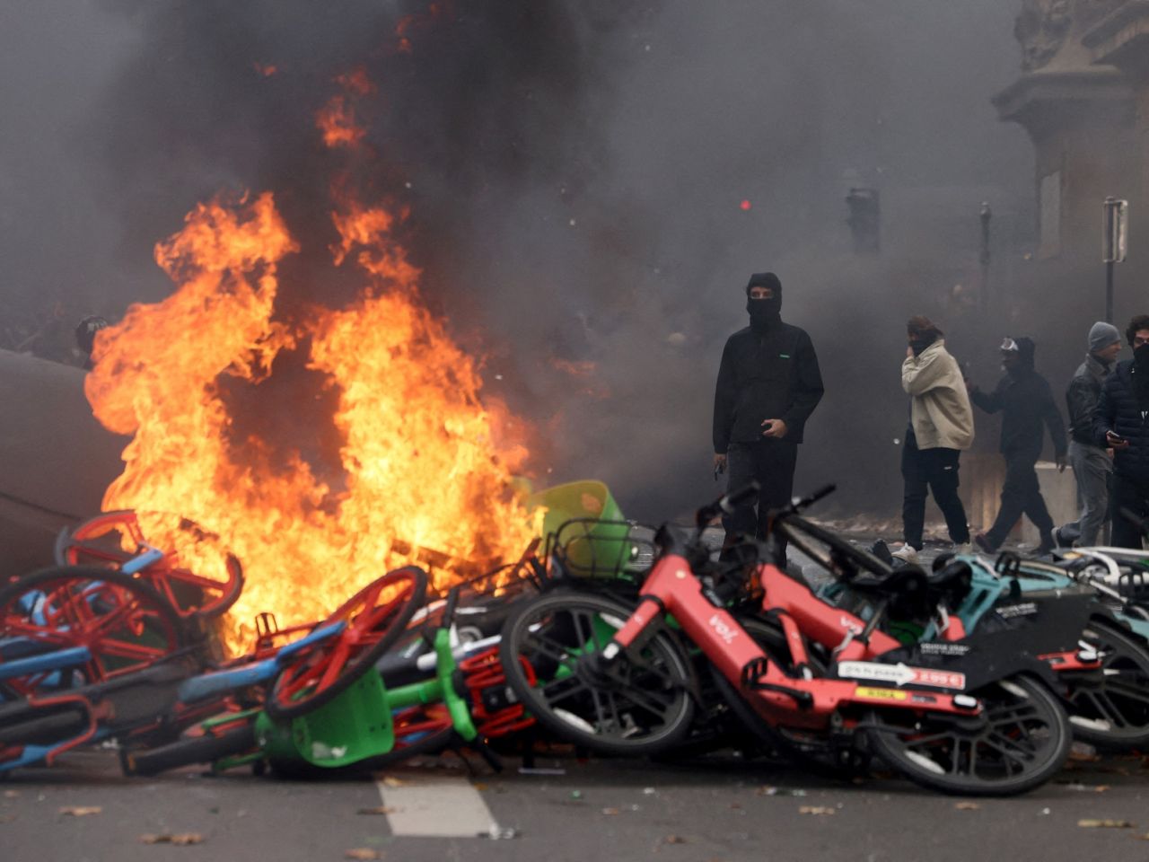 Masked protesters stand next to burning bicycles amid clashes during a demonstration against the cost of living and rising fuel prices near the Place de la Republique in Paris. Photo: Reuters