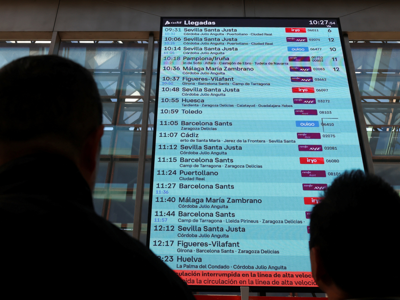 People check an information screen displaying a message that the high-speed train line between Madrid and Andalusia has been interrupted. Photo: Reuters